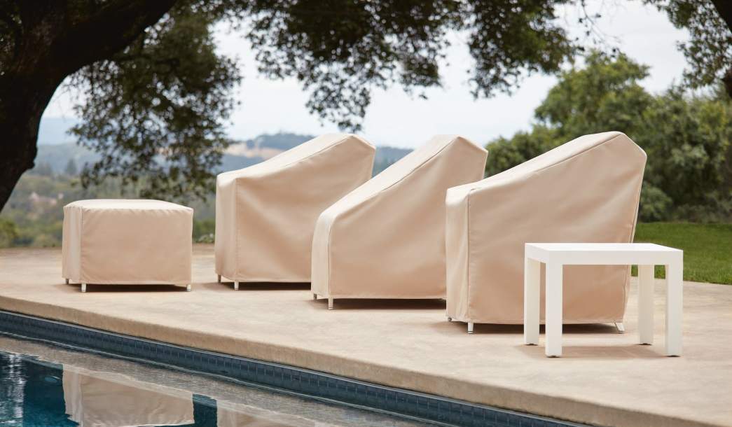 Image of McKinnon and Harris club chairs and ottoman with Protective Covers over them