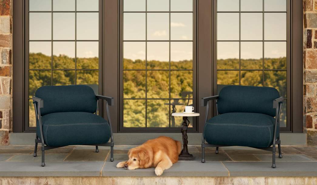 Image of Bastille Club Chair finished in Tappahannock Green with a Sculptura Drinks Table. A golden retriever dog is sitting in front of the chairs.