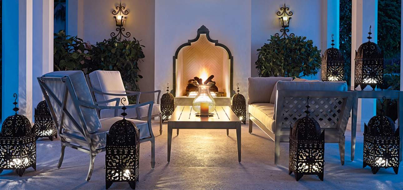 Beaufort Club Chairs around an outdoor fireplace at nighttime