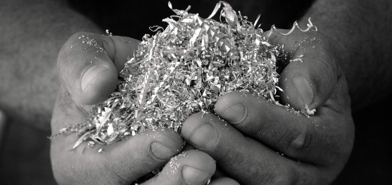 Image of McKinnon and Harris craftsperson holding scraps of aluminum in their hands
