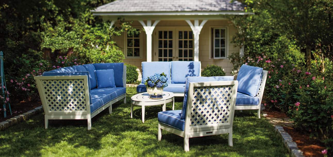 Duval Ensemble with Wyatt Coffee Table in a green backyard with the McKinnon and Harris logo on the top left of the image
