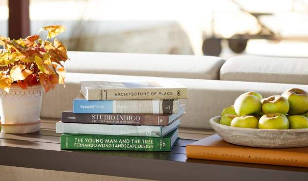 McKinnon and Harris Parsons Console Table finished in Jura Peat and styled with coffee table books, a fall plant and apples on top.