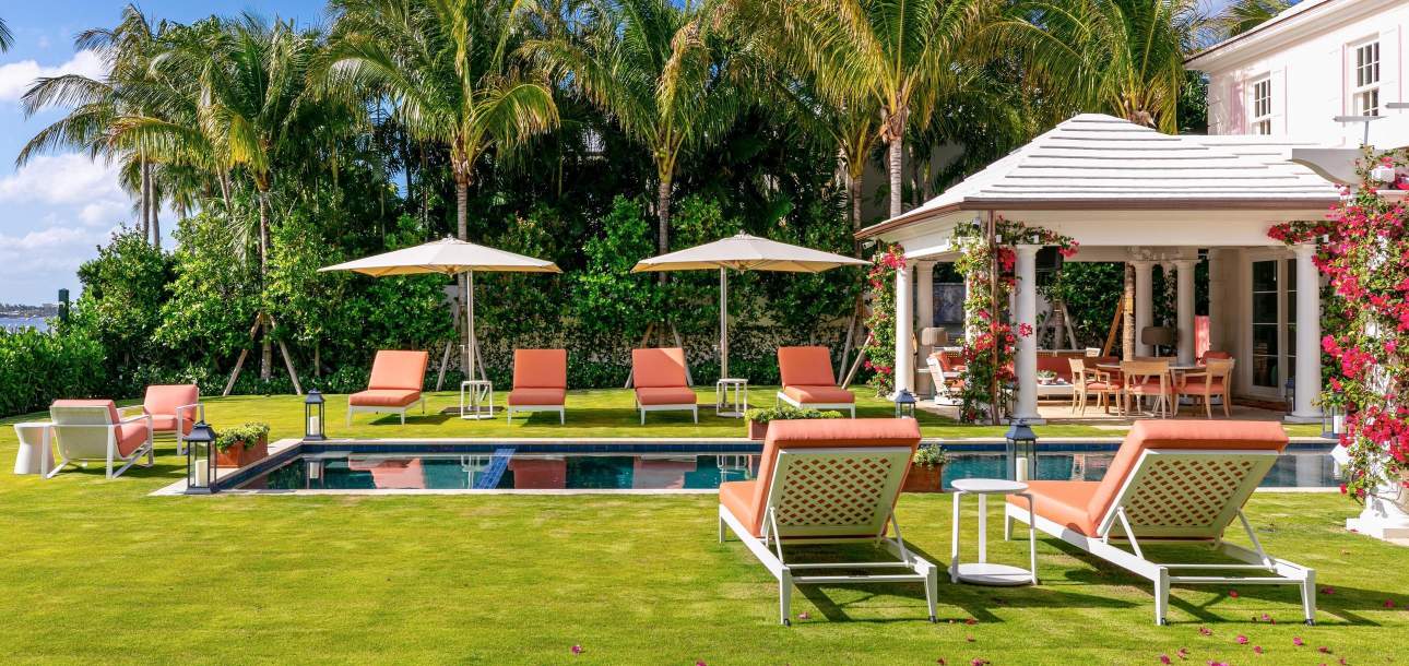 McKinnon and Harris duVal Sun Chaises with a coral fabric poolside at a home in Florida. Design by Scott Salvator.