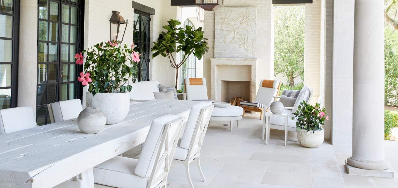 McKinnon and Harris Beaufort Dining Chairs and duVal Club Chairs on a covered terrace. Design by Suzanne Kasler.