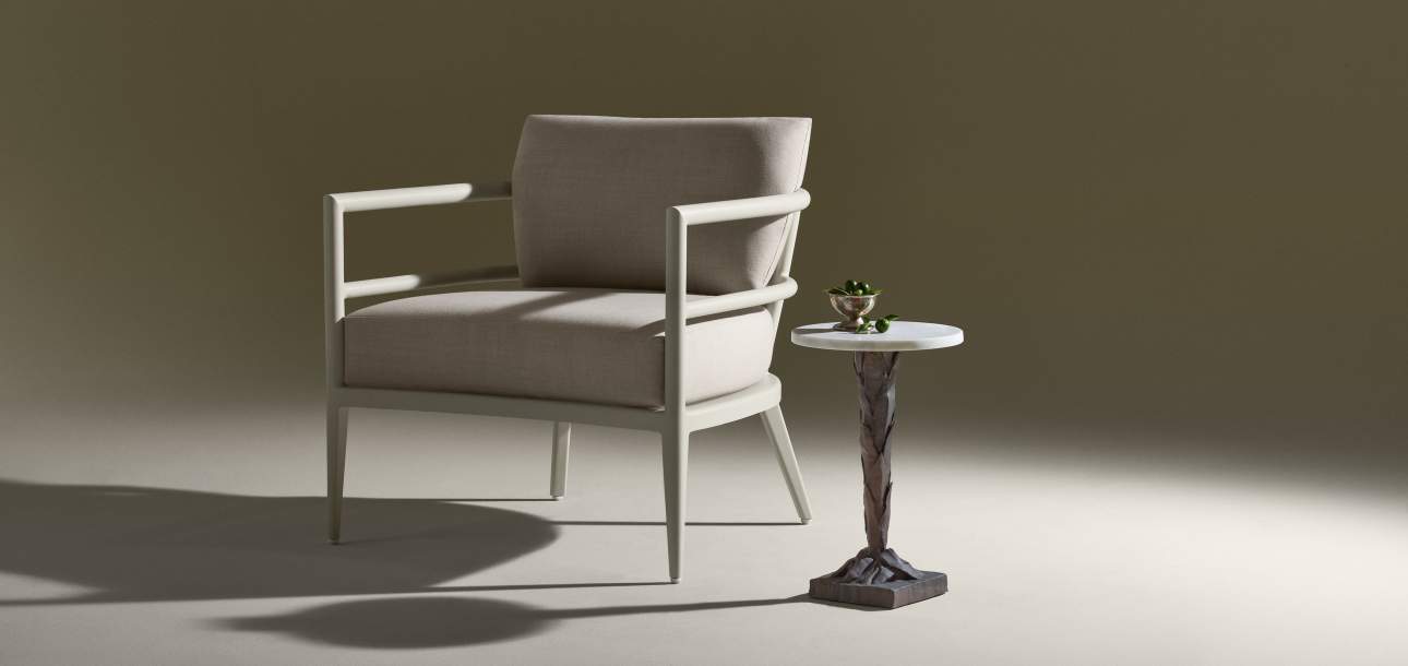 Image of McKinnon and Harris outdoor deCamp Lune Club Chair with performance fabric paired with Sculptura Drinks Table with Marmi natural stone top