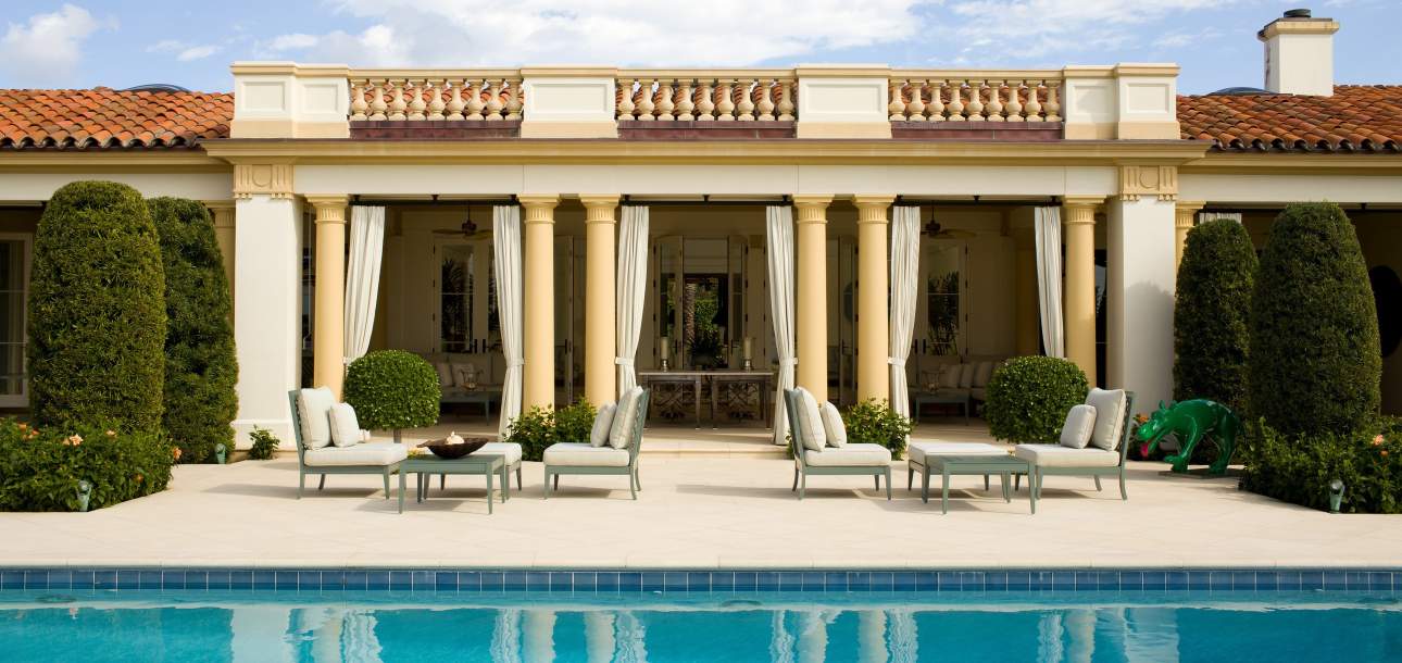 McKinnon and Harris duVal Petite Club Chairs poolside at a home in Florida. Design by Aman and Meeks.