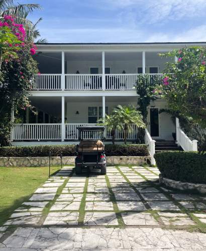 Image of exterior of Bahamas house with a golf cart parked outside