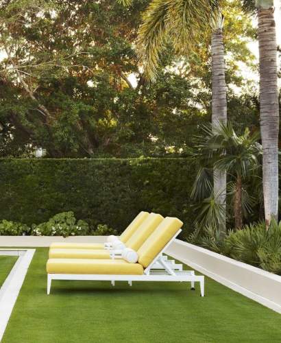 McKinnon and Harris duVal Sun Chaises in a bright yellow fabric poolside at a home in Florida. Design by Carrier and Co.