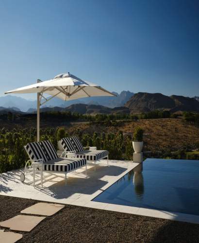 McKinnon and Harris Beaufort Double Sun Chaises poolside at a modern home in Las Vegas, Nevada. Design by Daniel Joseph Chenin.