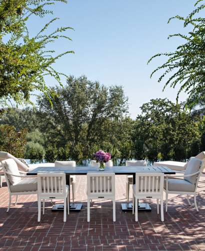 McKinnon and Harris duVal Portico Dining Chairs finished in Classic White and Carroll Dining Table finished in Traditional Black on a brick terrace