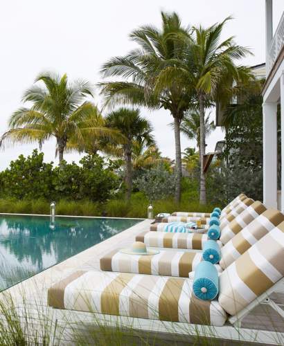 McKinnon and Harris duVal Sun Chaises with a striped fabric poolside at a home in the Bahamas. Design by Marshall Watson.