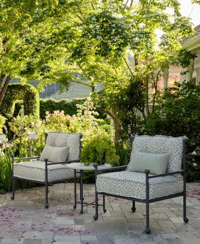 Thirza Club Chairs and Thirza Side Table with Natural Stone Top in a garden designed by Tucker and Marks.