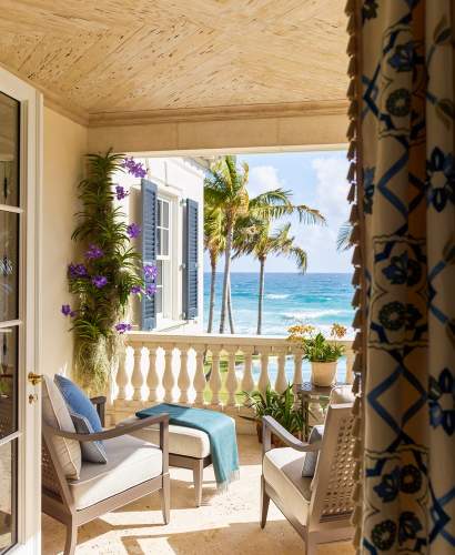 A pair of McKinnon and Harris duVal Club Chairs and Ottoman on a second story deck overlooking the ocean at a home in Florida. Design by Cullman & Kravis.
