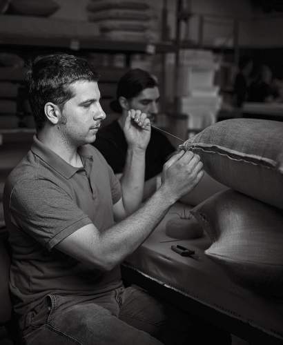 Dylan Hahn Upholstery Engineer sewing a throw pillow