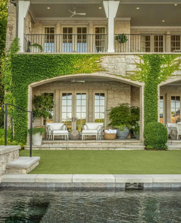 duVal-Alexander Club Chairs under a pergola with ivy growing on the sides poolside. Design by Beth Webb, Landscape Architecture by Stephen Hackney, Architecture by Stanley Dixon, Photos by Neil Landino