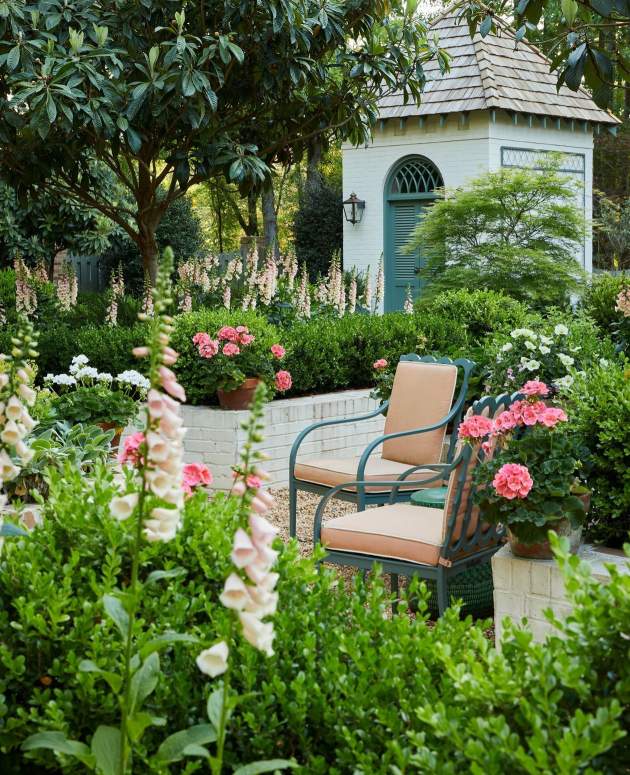 McKinnon and Harris Graves Dining Arm Chairs in a lush garden with flowers blooming. Design by James Farmer.