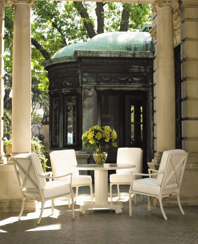 Albemarle Round Dining Table with Beaufort Dining Chairs surrounding it under a stone terrace