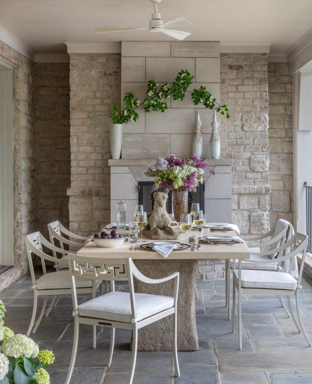 McKinnon and Harris Abbot Dining Arm Chairs paired with a rectangular stone dining table under a stone pergola. Design by Beth Webb, Landscape Architecture by Stephen Hackney, Architecture by Stanley Dixon, Photo by Lisa Romerein/OTTO