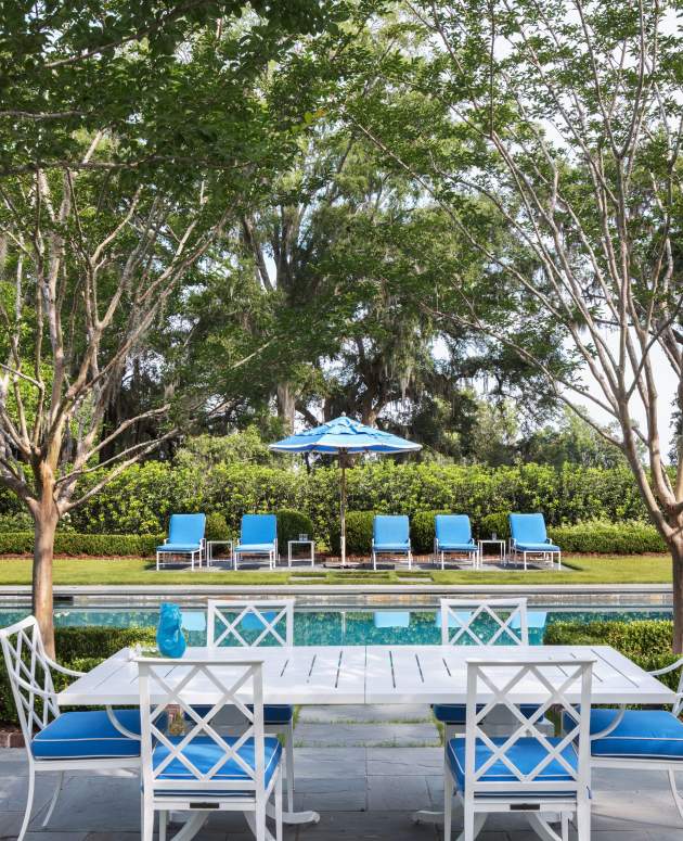 McKinnon and Harris Otey Dining Side Chairs finished in Classic White with bright blue cushions poolside at a home in South Carolina.