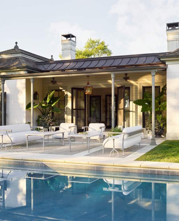 Dionysus Sculptura Coffee Table paired with the Bastille Collection shown poolside in front of a pool house