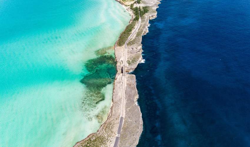 Image of Glass Window Bridge on Eleuthera. Water is turquoise on the left and inky blue on the right.