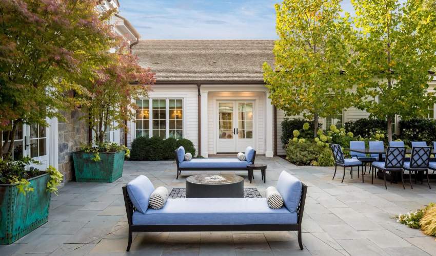 McKinnon and Harris duVal-Alexander Day Beds on a stone terrace at a home in Salt Lake City, Utah. Design by Hillary Taylor Interiors.