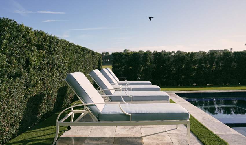 McKinnon and Harris Otey Sun Chaises. Finished in Classic White with Porto Equator Fabric. At a home in Ponte Vedra Beach, Florida, designed by Emily Painter and photographed by Blake Shorter.