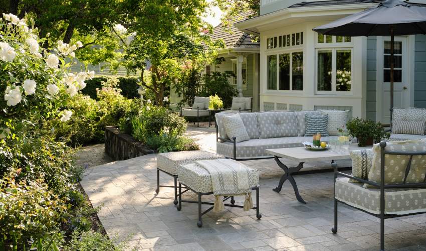 Thirza Club Chairs and Sofa with Skye Coffee Table with a Natural Stone Top in a garden designed by Tucker and Marks.
