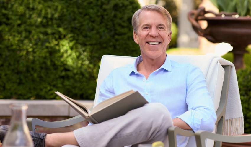 McKinnon and Harris co-founder Will Massie sitting in his garden reading a book