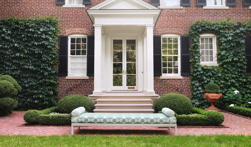 Couper Backless Bench pictured in front of a brick house