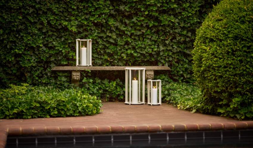 Leggett Lanterns shown in Gwynn’s Island Gray on a bench on a brick patio