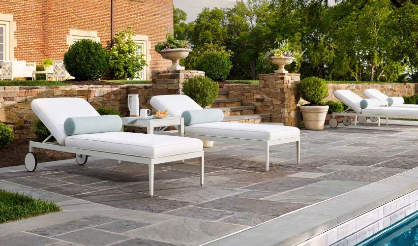 Rives Sun Chaise finished in York River Oyster poolside on a stone patio
